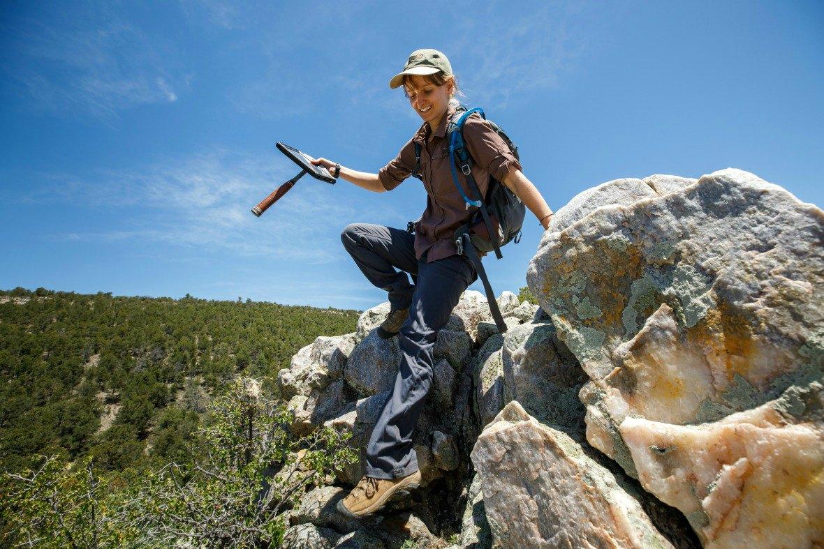 A student climbs down rocks at Field Camp